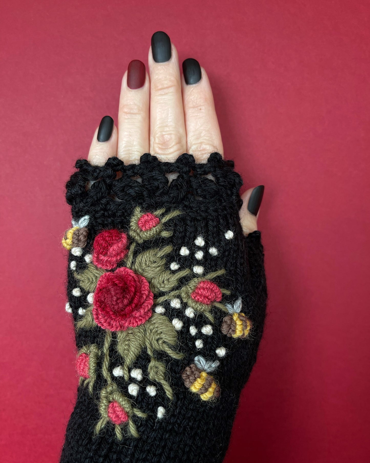 Black hand knitted gloves with embroidered red roses and bees