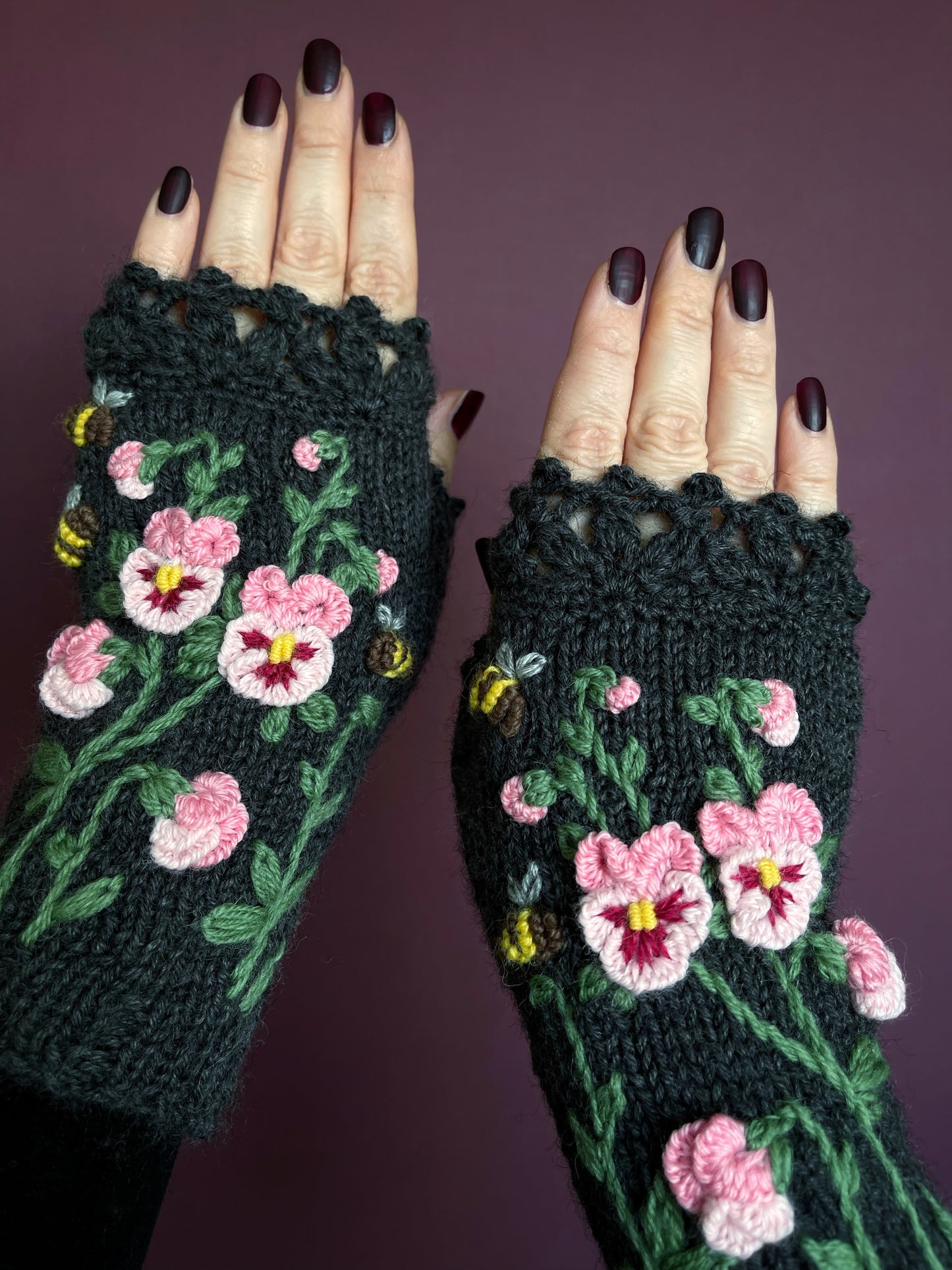 Dark gray hand knitted gloves with pink pansy flowers embroidery