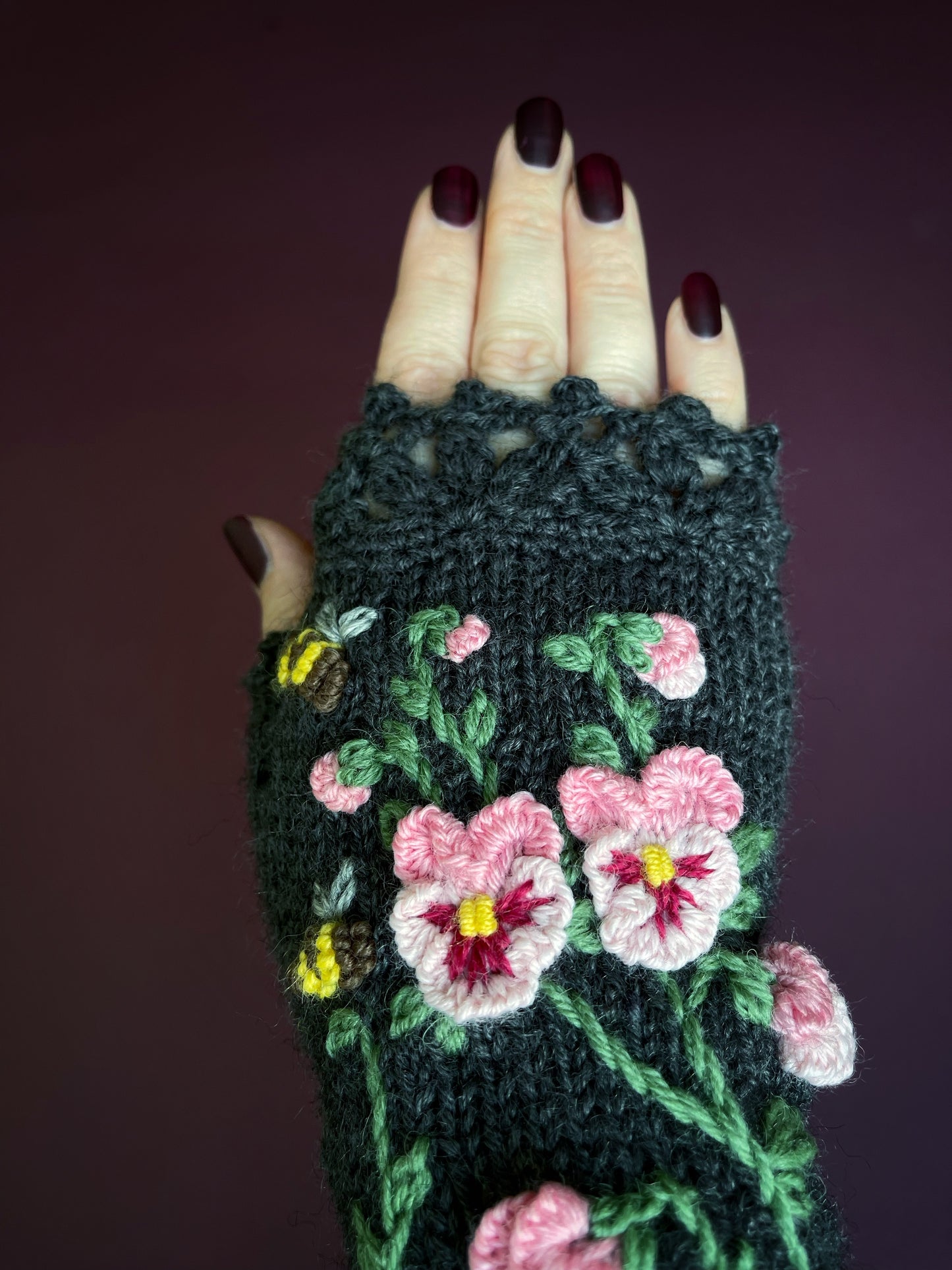 Dark gray hand knitted gloves with pink pansy flowers embroidery