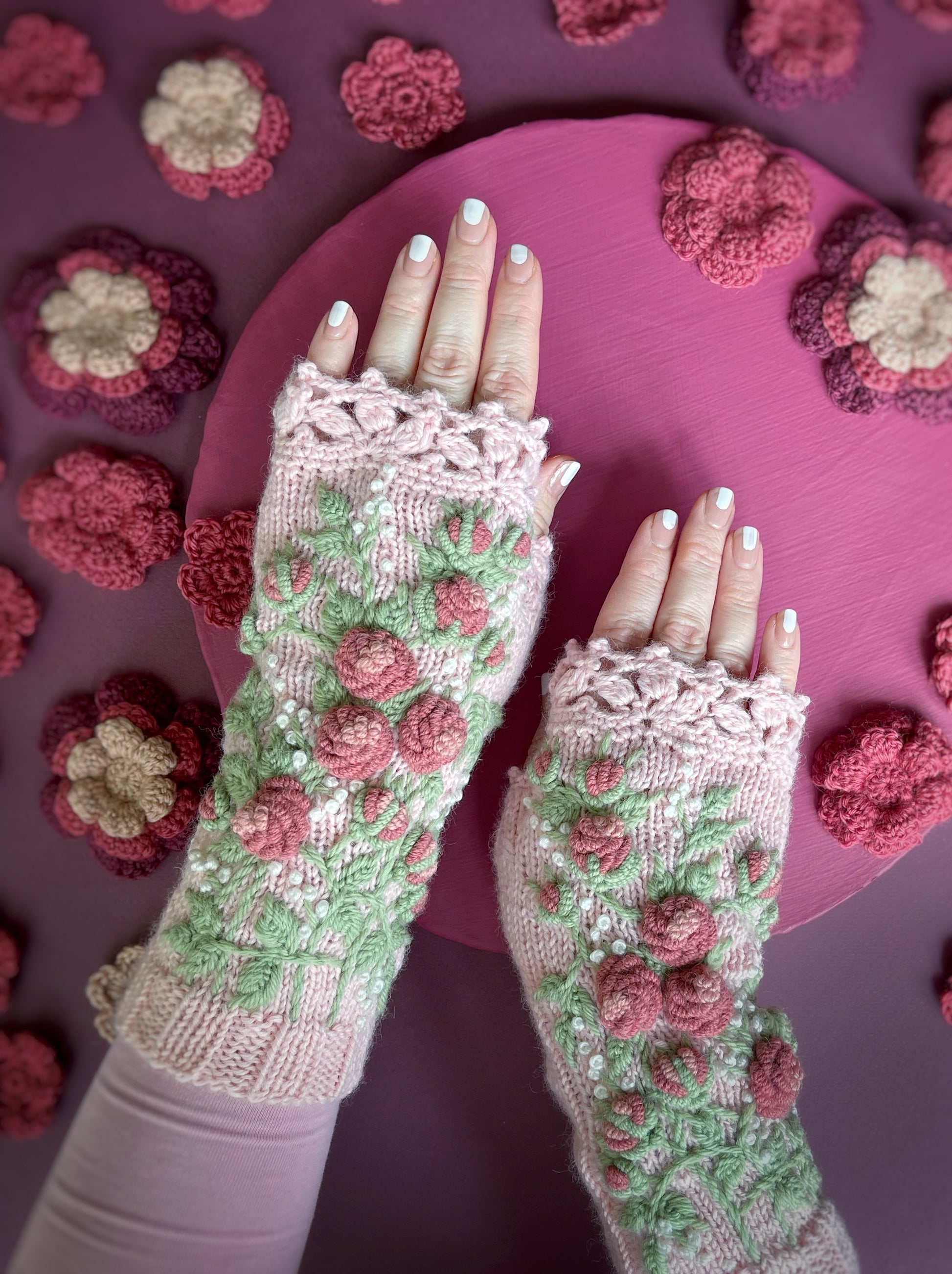 Hand knitted pink gloves with embroidered roses